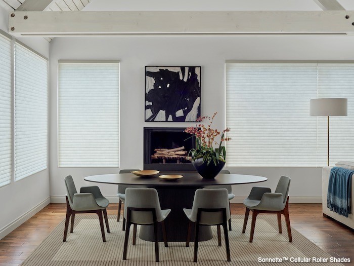 A dining room with black and white painting and a black vase.